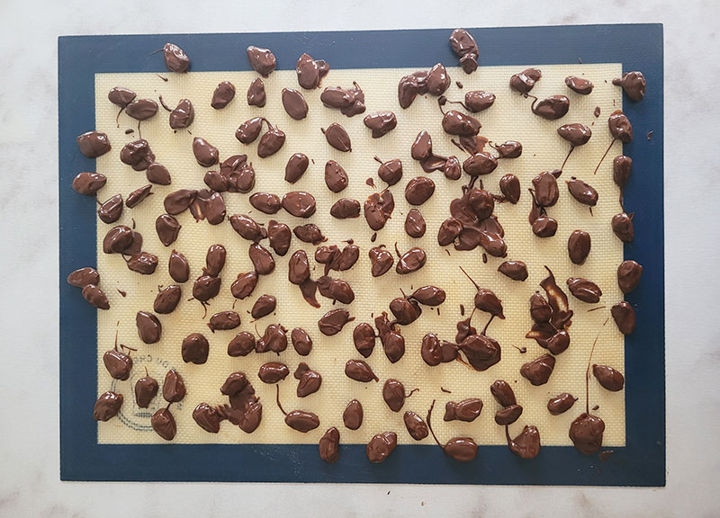 Amandes enrobées de chocolat noir sur un tapis en silicone